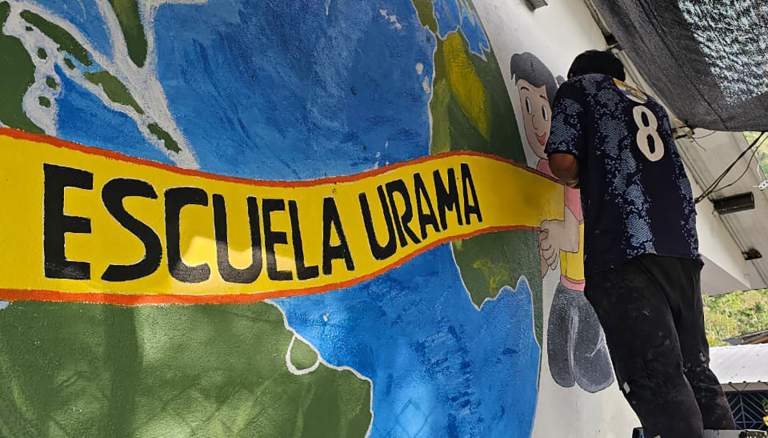 Estudiante de la institución educativa Urama, ayudando a pintar el mural